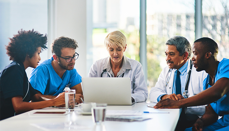 A doctor demonstrating their clinic management system to her colleagues.