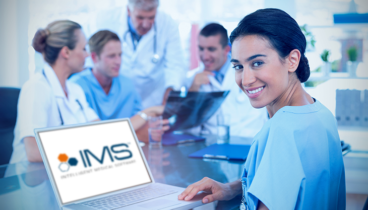 A female doctor using a laptop displaying the IMS logo while 4 other healthcare workers huddle in the background.