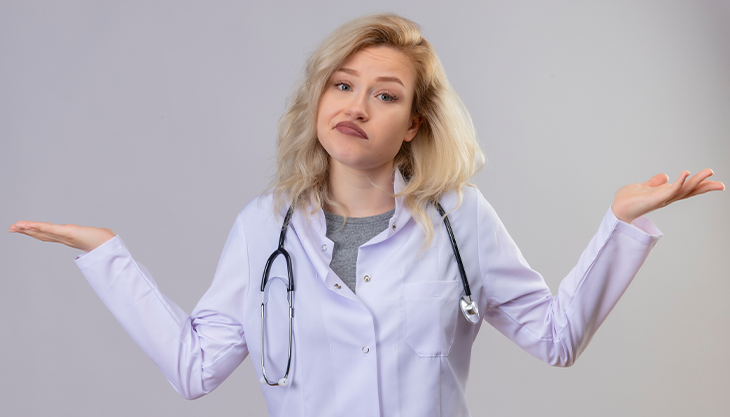 A female doctor shrugging her shoulders and throwing her hands up.