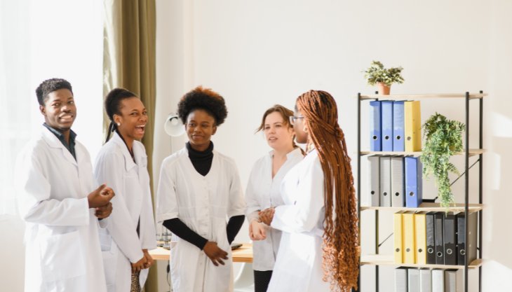 Five doctors gathered in a circle talking to each other showing strong provider-to-provider communication.