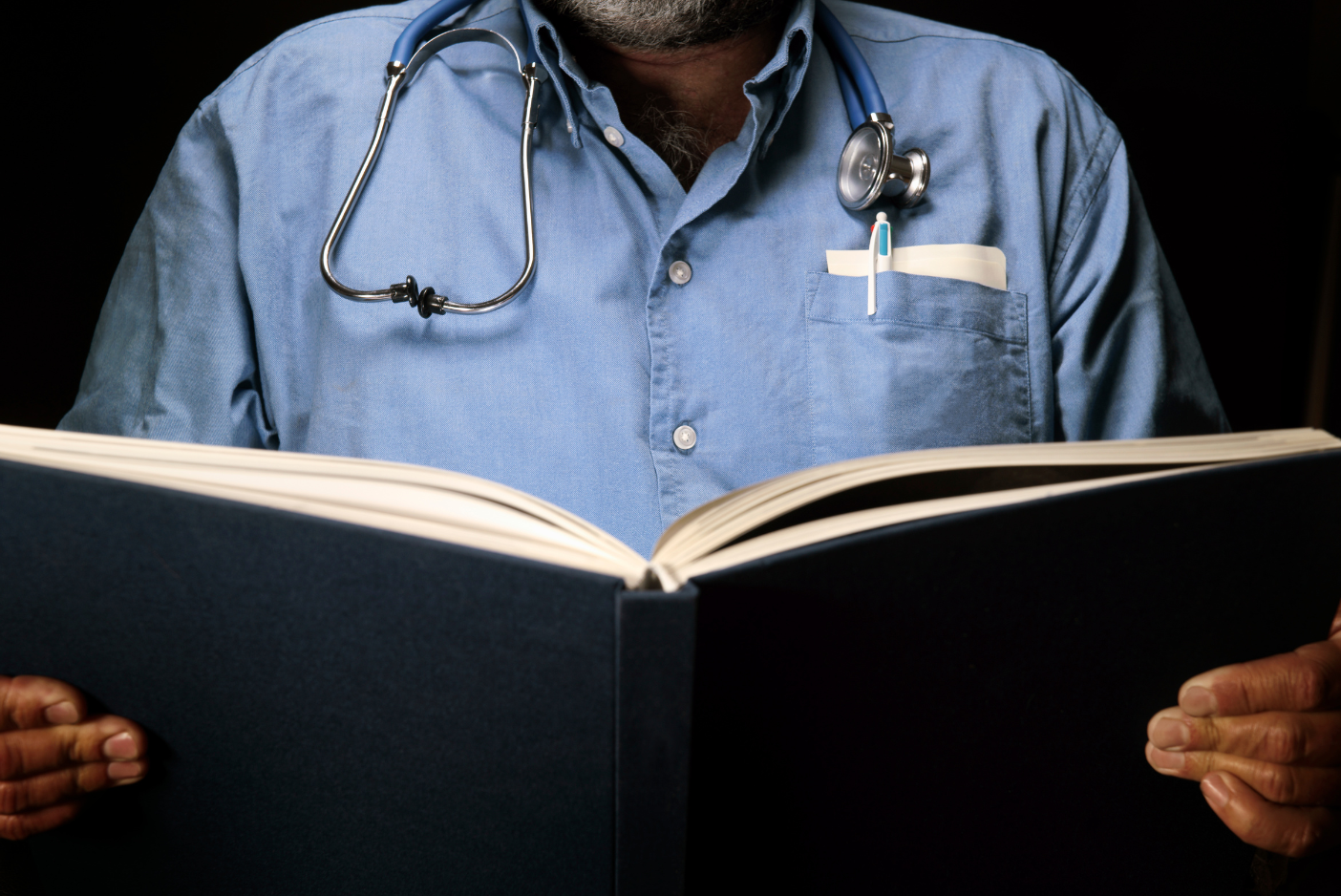 A doctor looking at a book for reference