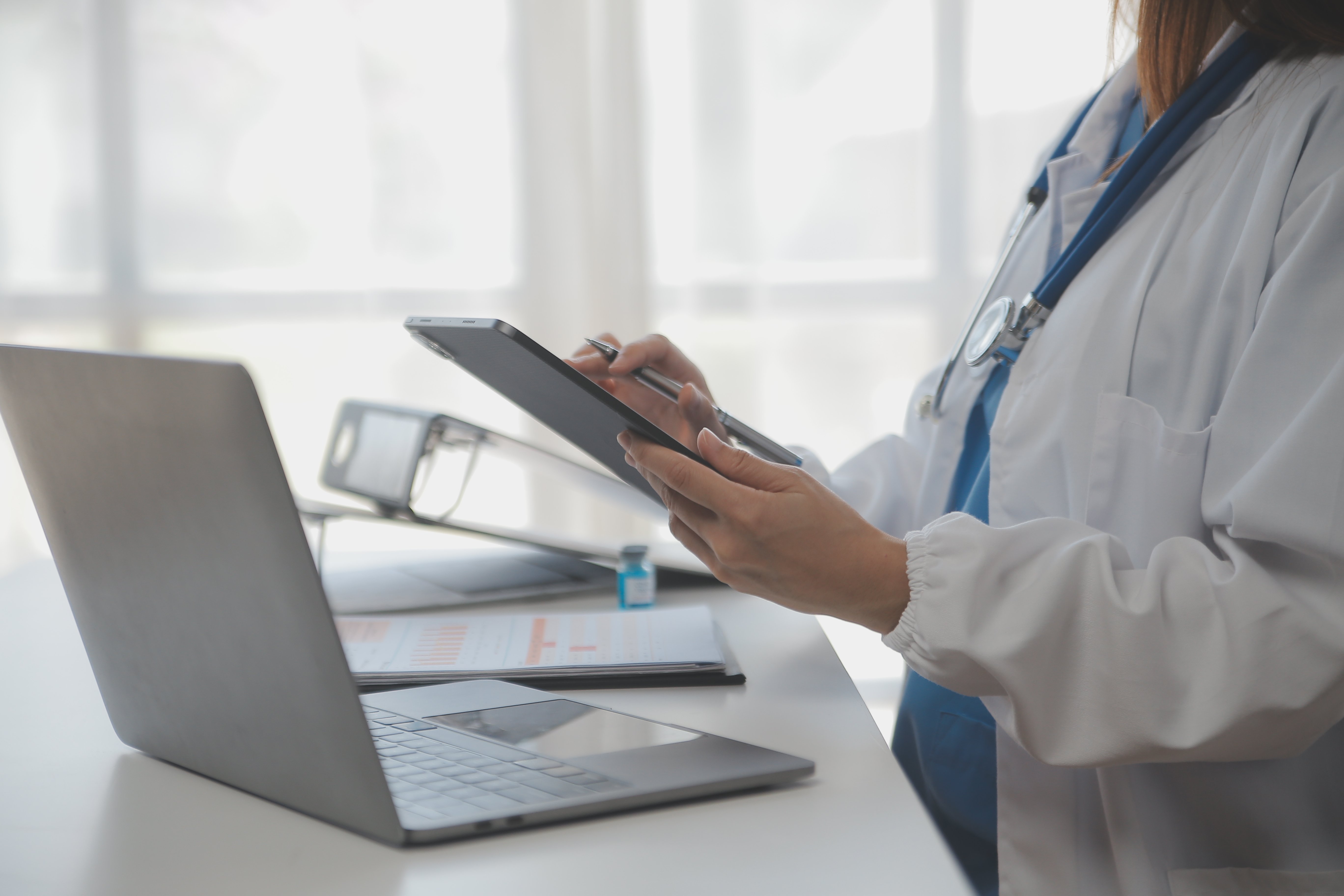 Doctor using their EHR solution from both laptop and tablet