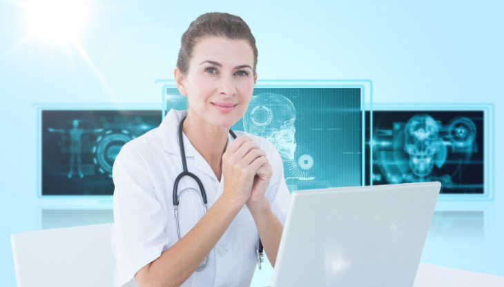 A female doctor smiling while navigating her medical office software on her laptop.