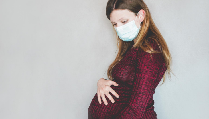 Pregnant woman with a face mask because of COVID-19