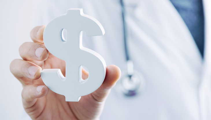 Doctor holding wooden dollar sign to represent $25.5 Billion in COVID-19 Provider Relief